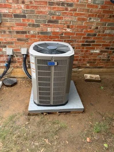 New American Standard condenser installed on a fresh concrete pad